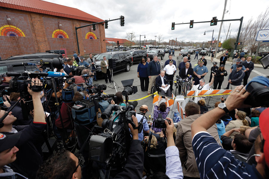 Massachusetts Gov. Deval Patrick, address members of the media near a the search area for a suspect in the Boston Marathon bombings, Friday, April 19, 2013, in Watertown, Mass.  The two suspects in the Boston Marathon bombing killed an MIT police officer and hurled explosives at police in a car chase and gun battle overnight that left one of them dead and his brother on the loose, authorities said Friday.  (AP Photo/Matt Rourke)