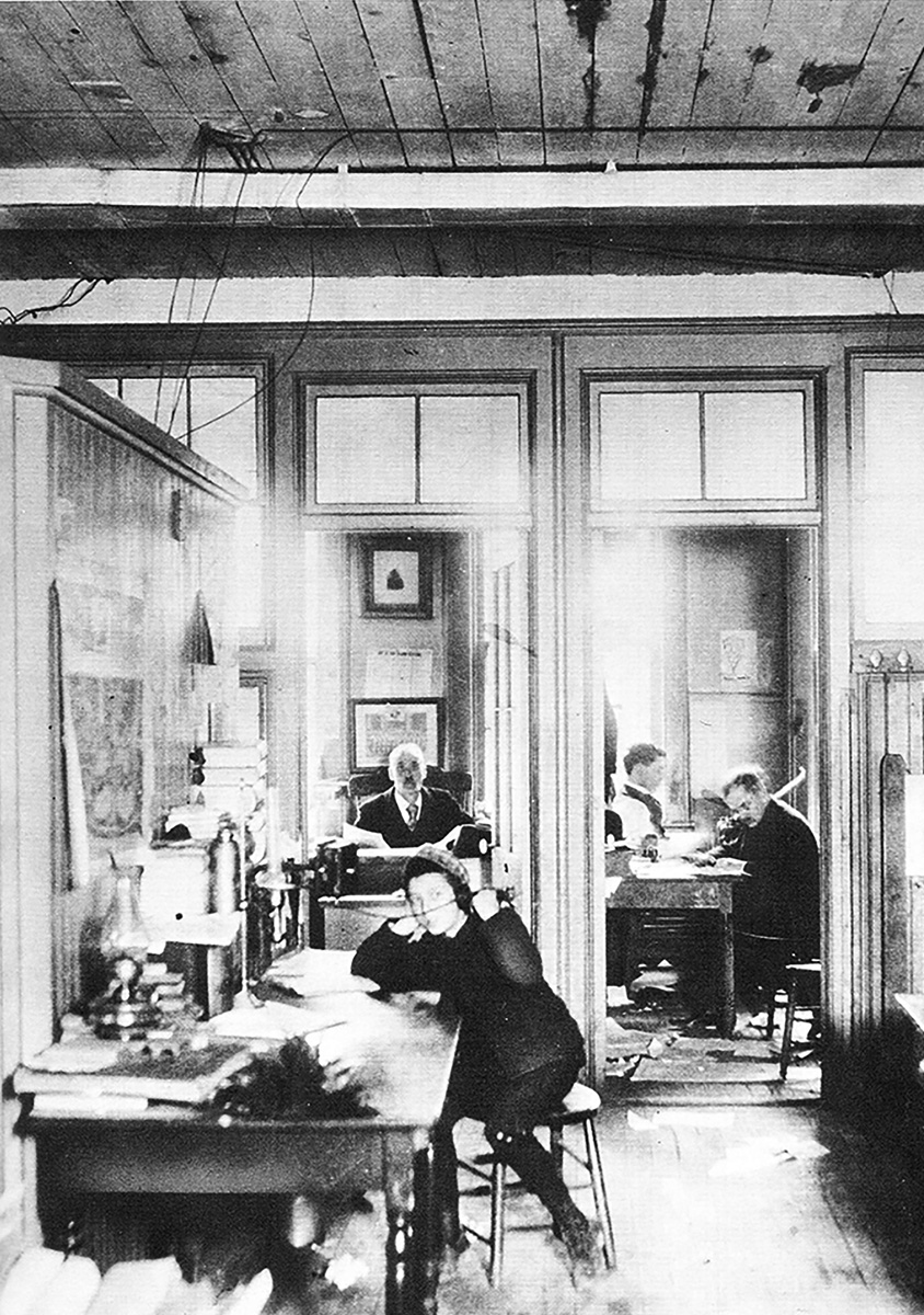 Lucius W. Nieman, shown at rear, in the office of The Milwaukee Journal circa 1885, three years after he joined the paper. An office boy answered the phone at the front desk and reporters used the office at right