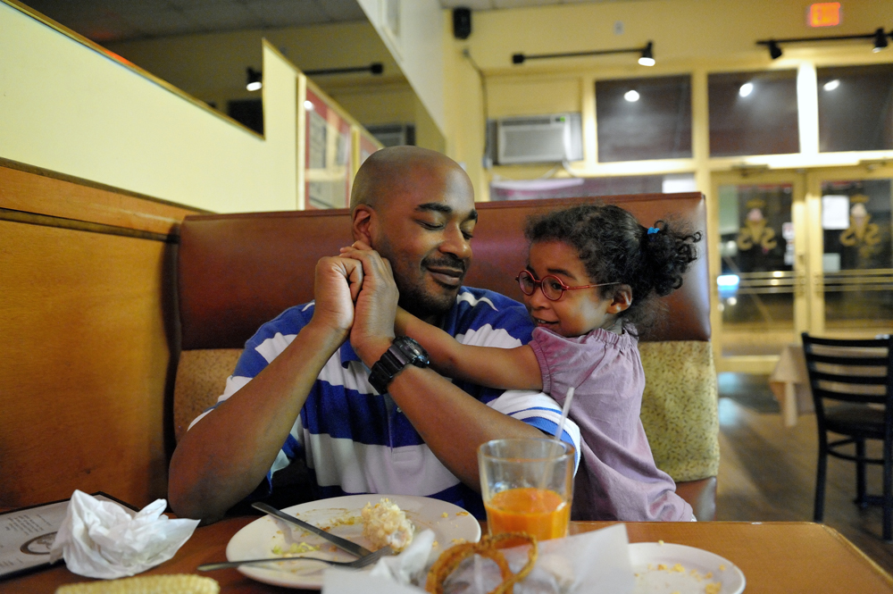 Carlos Richardson and his daughter Selah enjoy a quiet moment after dinner in Atlanta, Georgia