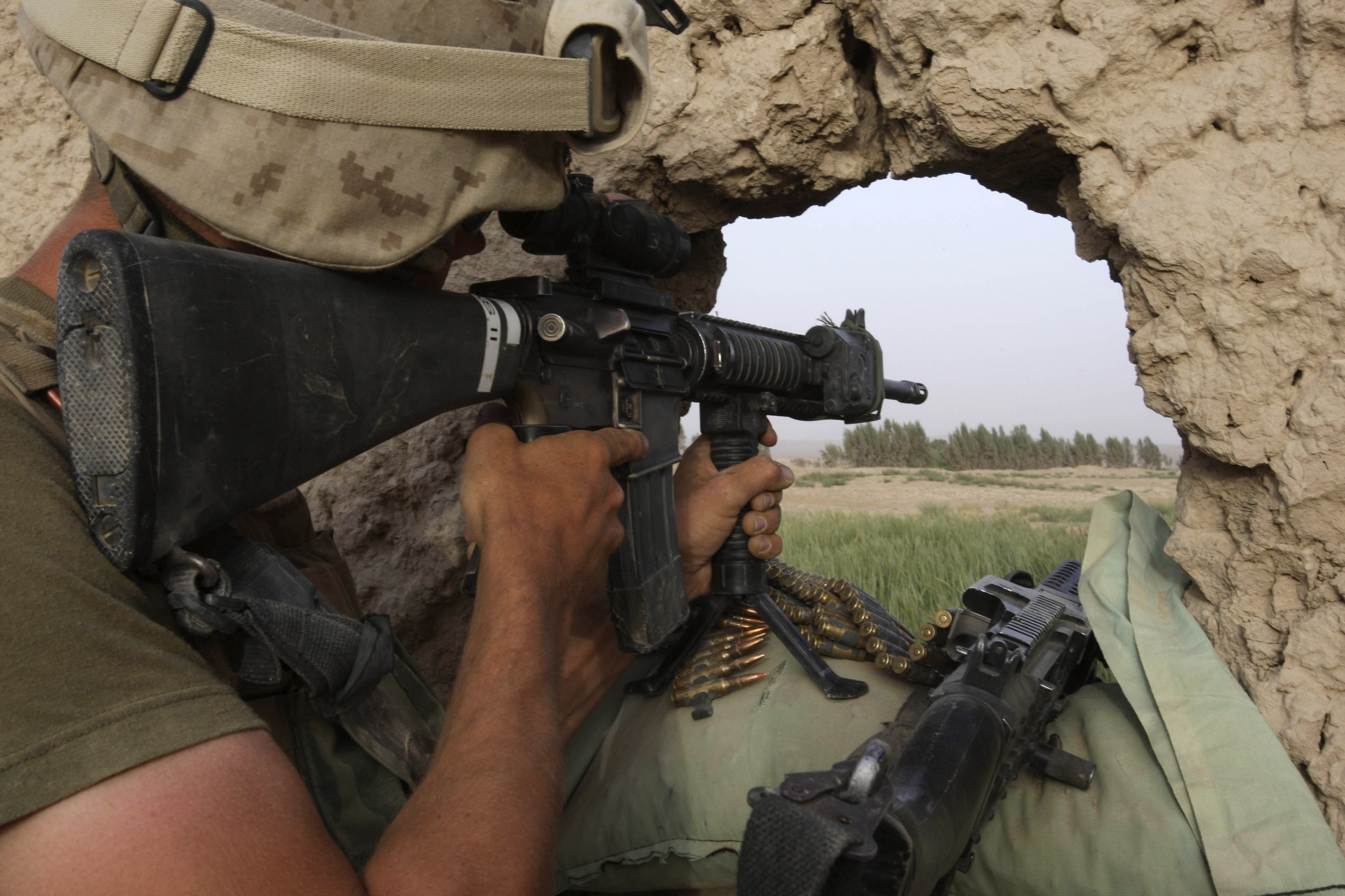 A U.S. Marine from the 24th Marine Expeditionary Unit observes after firing on a Taliban position near the town of Garmser in Helmand Province, Afghanistan, in May 2008.