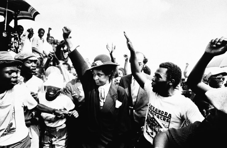 Winnie Mandela, then the wife of jailed ANC leader Nelson Mandela, raises her fist during the 1986 funeral for 17 blacks who had been killed in Johannesburg's Alexandra township.