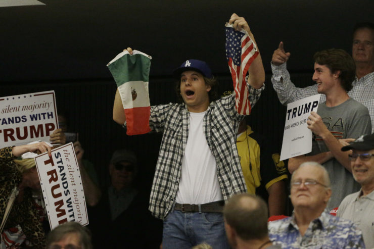 A protester holds U.S. and Mexico flags during a rally with Republican presidential candidate Donald Trump at the Anaheim Convention Center in May