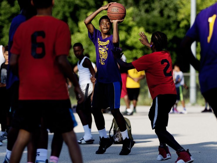 Wesley Higgans takes a shot at a game at Milwaukee's Meaux Park. A three-part Precious Lives project followed a youth basketball team coping with the death of a star player who was killed in an accidental shooting