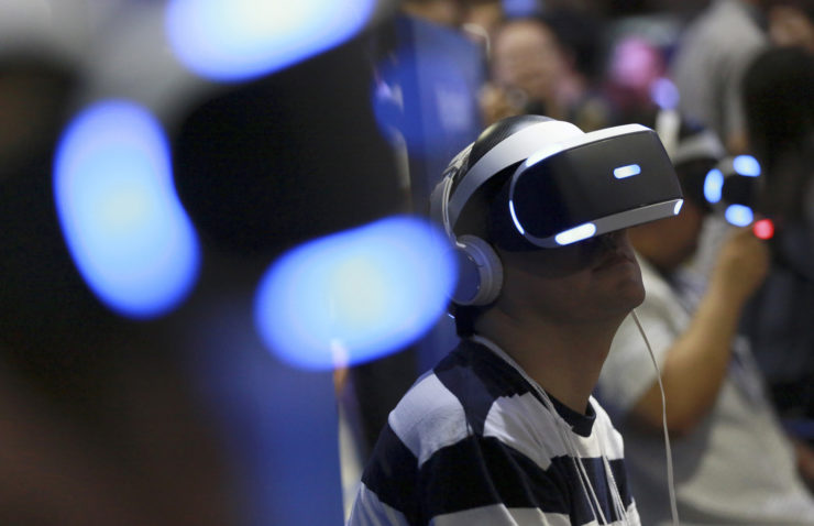 Visitors try out Sony's PlayStation VR headgear devices at the Tokyo Game Show