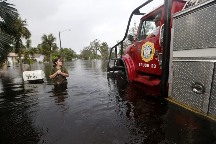 Firefighters check on Kelly McClenthen, who returned to check on the damage to her flooded home in the aftermath of Hurricane Irma in Bonita Springs, Florida