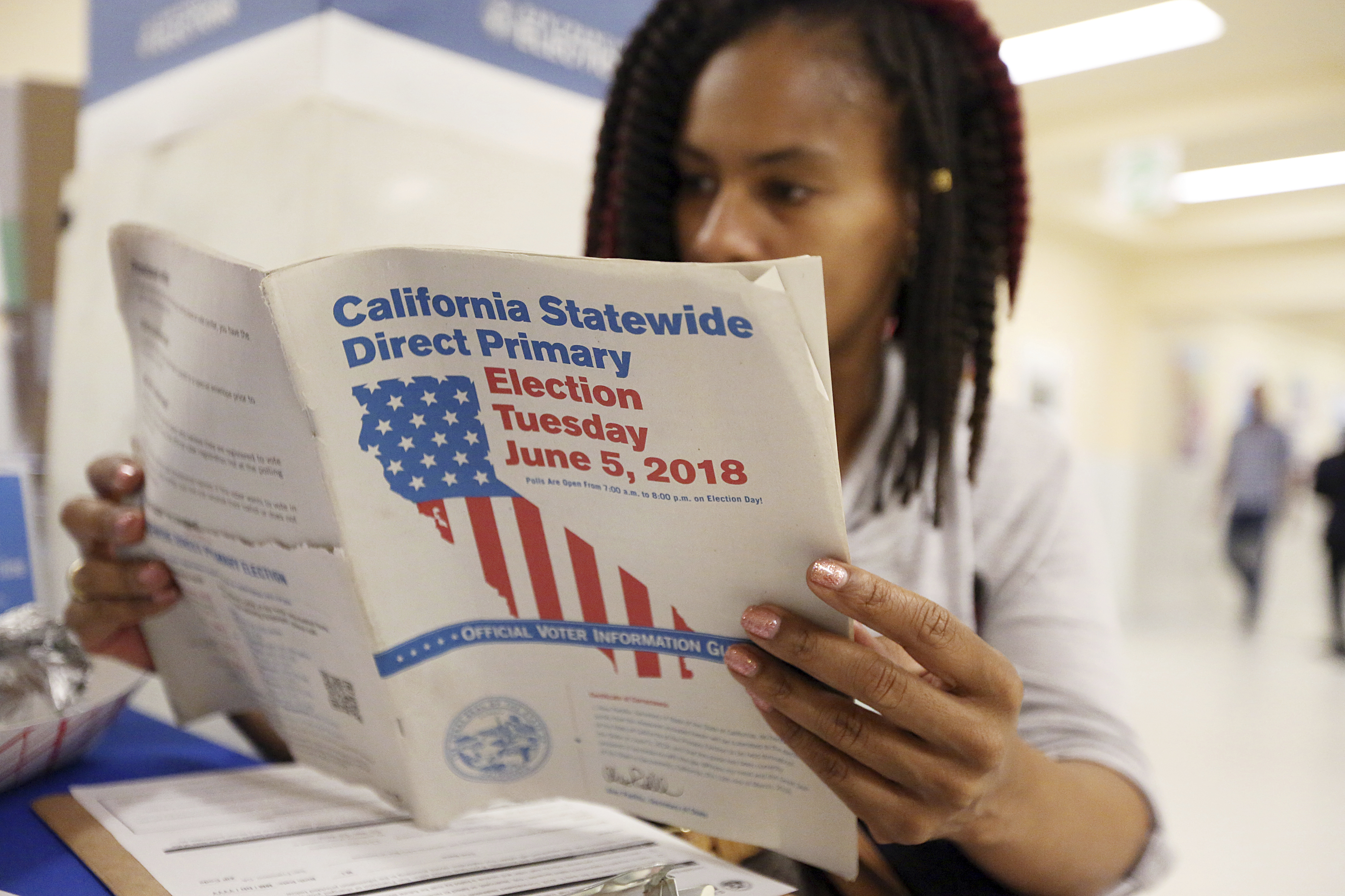 A woman reviews the California Primary election guide at San Francisco City Hall on June 5. To cover California’s key state races and propositions for voters, CALmatters created an accessible and comprehensive 2018 election guide