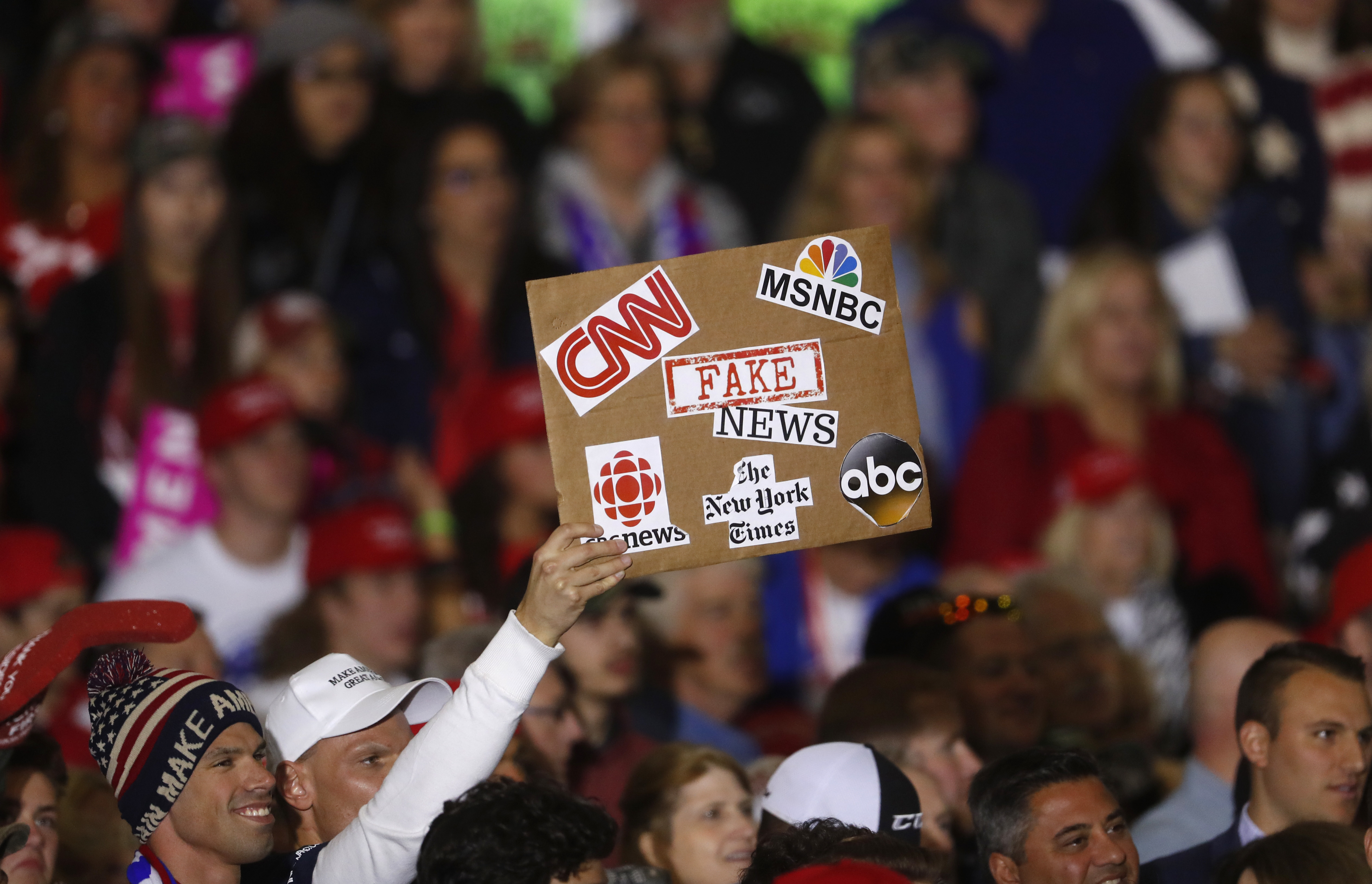 An audience member holds a fake news sign during a President Donald Trump campaign rally in Washington Township, Michigan