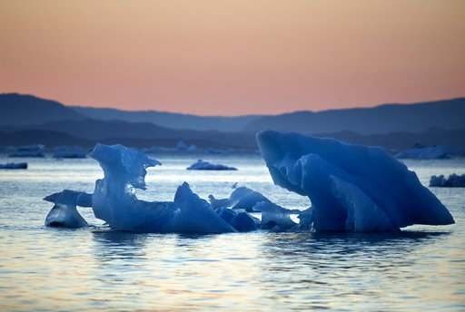 The suns sets as an iceberg floats in the Nuup Kangerlua Fjord near Nuuk in southwestern Greenland, in August 2017. Greenland's glaciers have been melting and retreating at an accelerated pace in recent years due to warmer temperatures. If all of that ice melts, scientists say sea levels will rise by several meters.