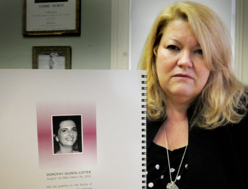 Suzanne Dubus, CEO of the Jeanne Geiger Crisis Center, holds a manual on Domestic Violence High Risk Team. The manual features a photo of Dorothy Giunta-Cotter, who was killed by her husband in Amesbury, Mass., in 2002.  
