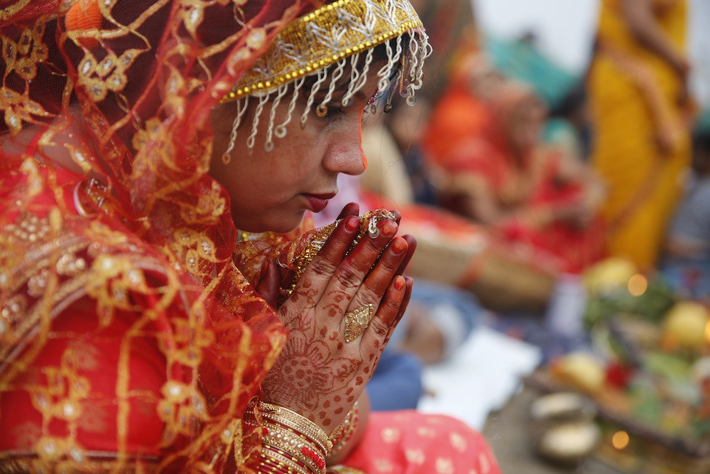A woman prays during Chhath, an ancient Hindu festival during which rituals are performed to thank the sun god for sustaining life on earth, in Prayagraj, India in November 2019