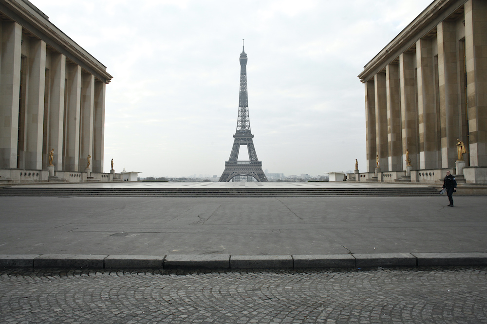 A police officer walks in the empty Trocadéro square, in Paris