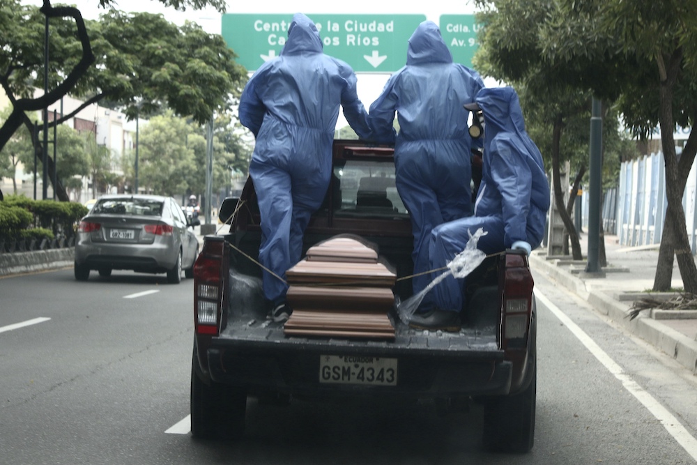 Empleados de un cementerio, transportan con equipo de protección los restos de una persona que será enterrada en el Cementerio General en Guayaquil, Ecuador el jueves 9 de abril de 2020 