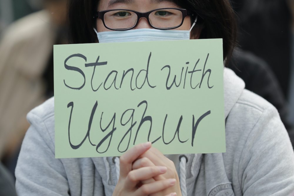 A man holds a sign during a 2019 rally in Hong Kong to show support for Uighurs and their fight for human rights. Radio Free Asia (RFA) was the first to report on the mass detention of Uighur Muslims in the Xinjiang region of China
