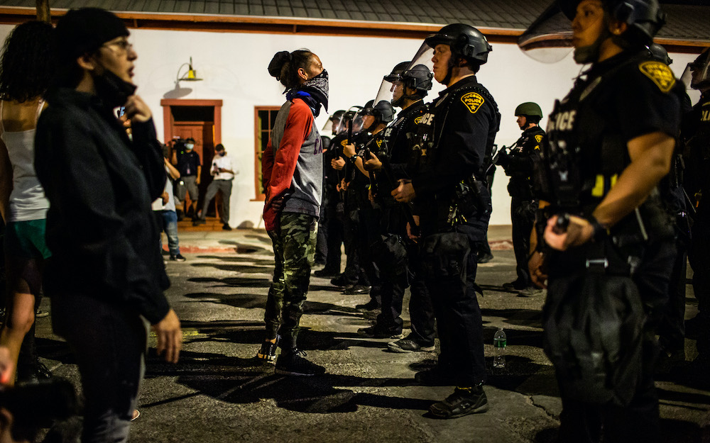 Protestors face a line of Tucson, Arizona police officers during a May protest following the killing of George Floyd