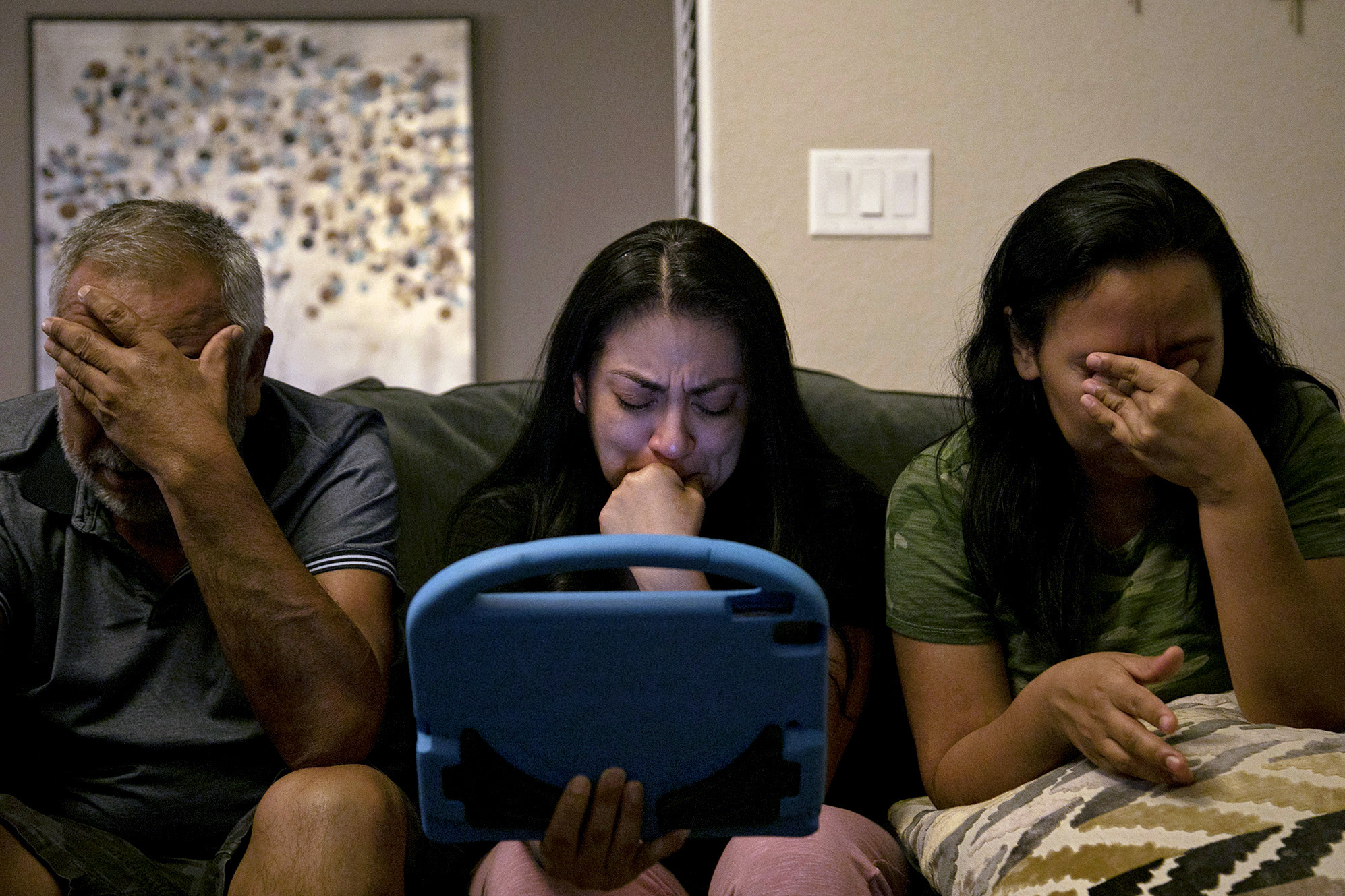 Vanessa Dyer, center, her sister, Alex Vasquez, and their father, Enrique Rangel, are brought to tears as they and their brother Andy Rangel, on FaceTime, speak to their mother, Leonor "Nora" Rangel, who was on a ventilator at San Antonio’s Southwest General Hospital