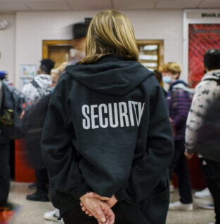 Anita Kanzaki, a member of the Bradley-Bourbonnais Community High School security staff, watches students walk between classes in January 2022.